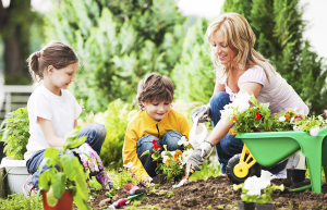 Mother, daughter and son planting flowers together.